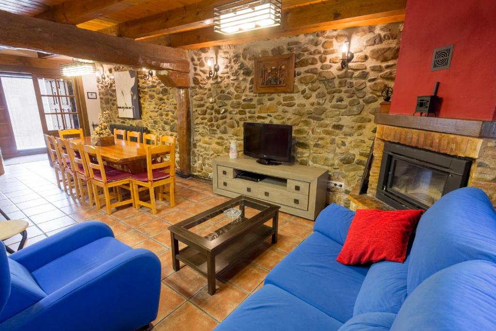 a living room with a blue couch and a fireplace at La Casita del Oja in Ojacastro