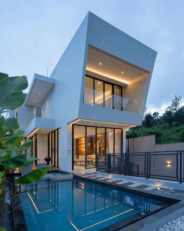 a house with a swimming pool in front of it at Alcola Boutique Villa - Bahama Unit in Malang