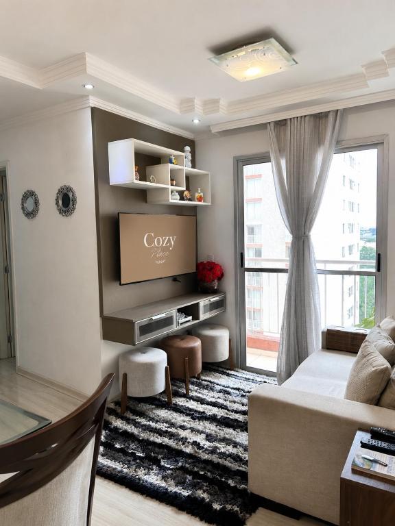 a living room with a couch and a large window at Cozy Place Curitiba in Curitiba