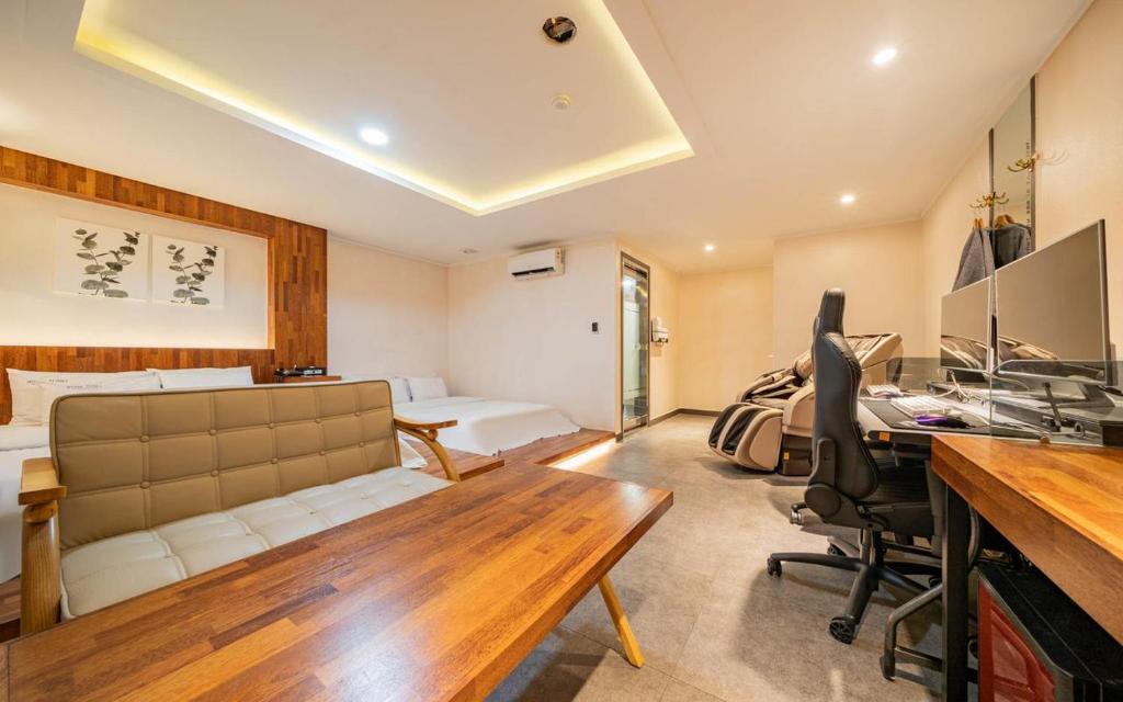 a living room with a couch and a desk in a room at Bupyeong Byulha Hotel in Incheon