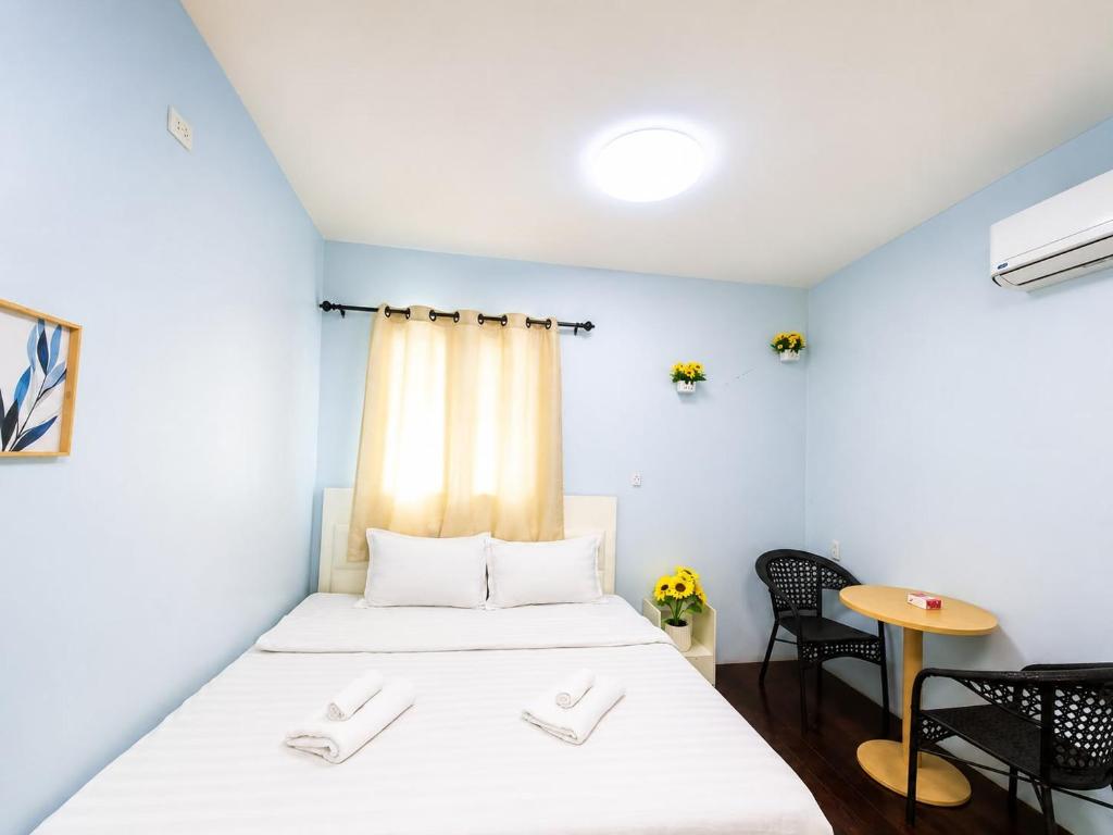 a small room with a bed and a table at Magic Garden Residence Bangkok in Bangkok
