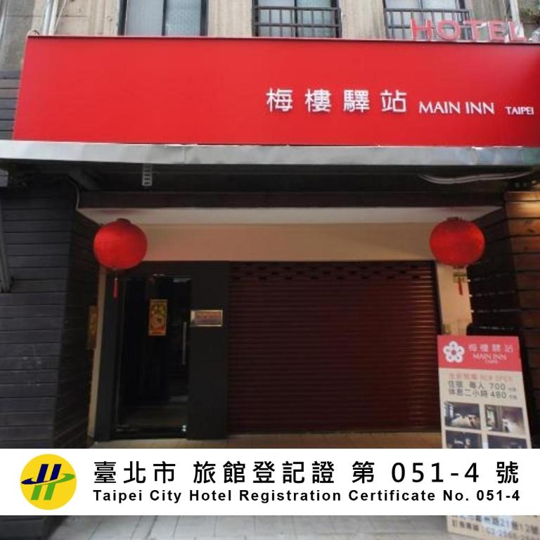 a building with a red sign on the front of it at Main Inn Taipei in Taipei