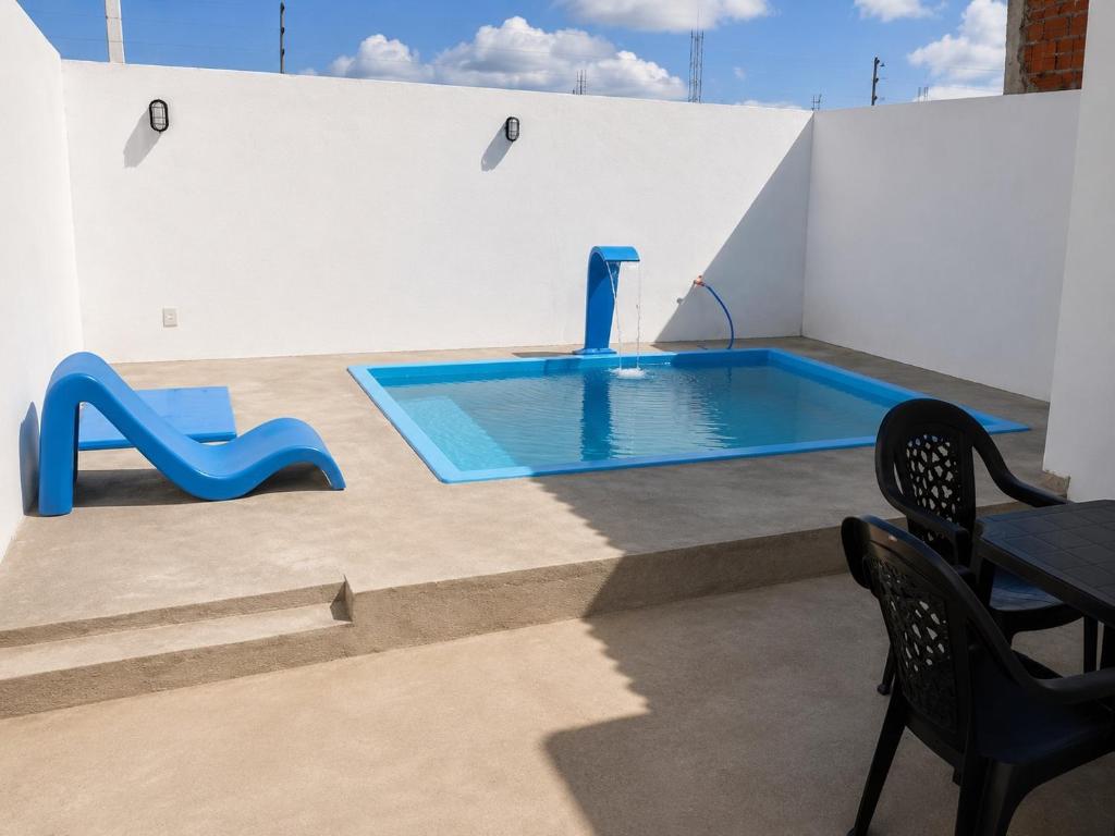 a swimming pool with a table and chairs next to it at Villa Penelope in Paracuru