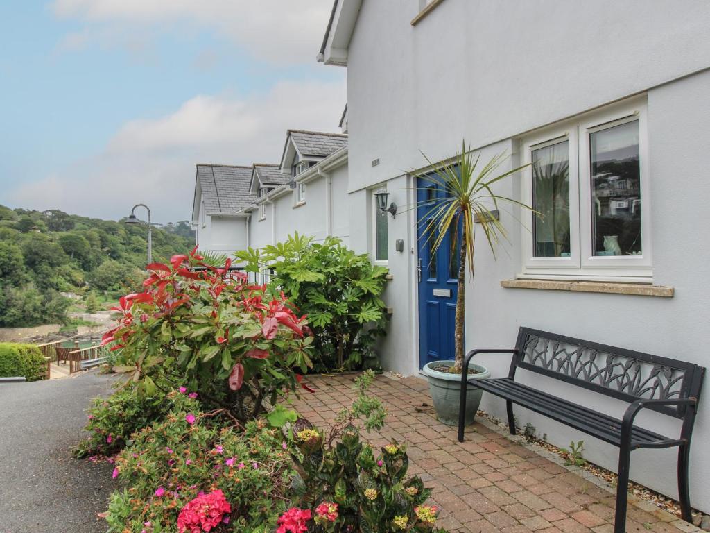 a bench in front of a house with flowers at 16 Bolt Head in Salcombe