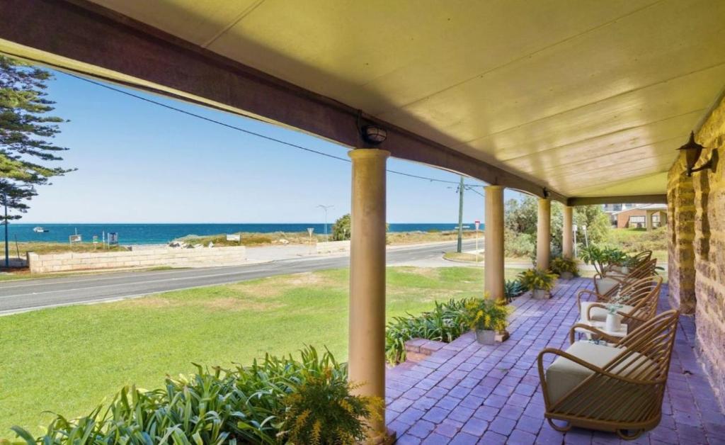 a porch with benches and a view of the beach at Ardgreian in Safety Bay