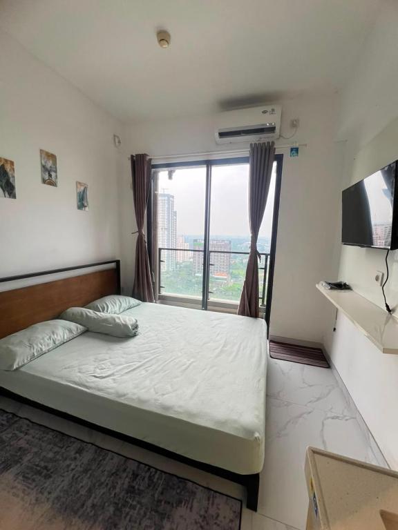 a bedroom with a bed and a large window at Sky House BSD By Micky Studio in Cilenggang