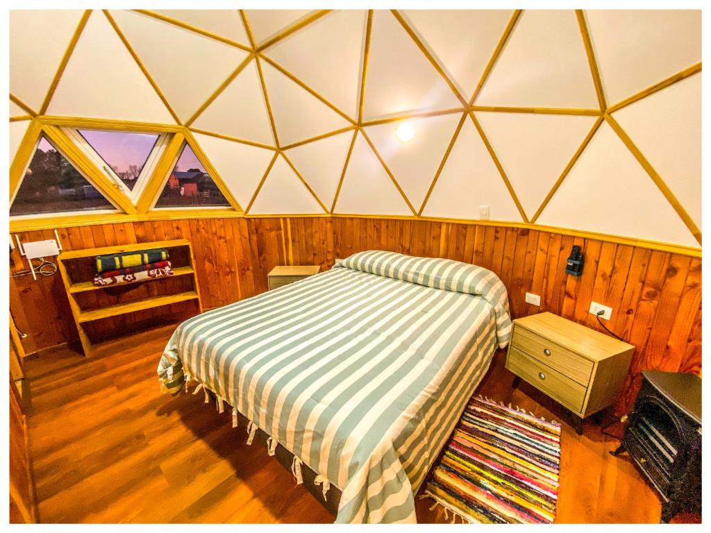 a bedroom with a bed in a triangular room at Domos Frutillar in Frutillar
