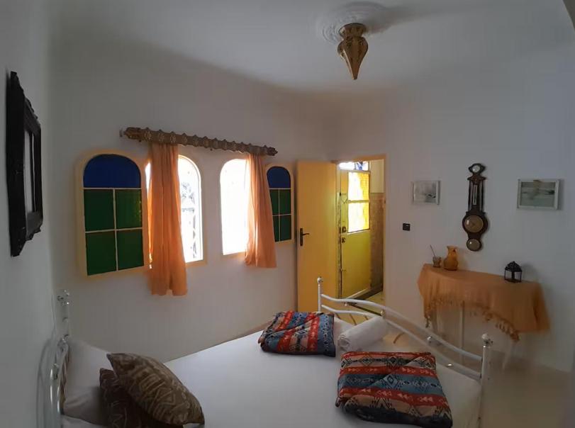 a bedroom with a bed and two windows at San Marcelo De Tangier in Tangier
