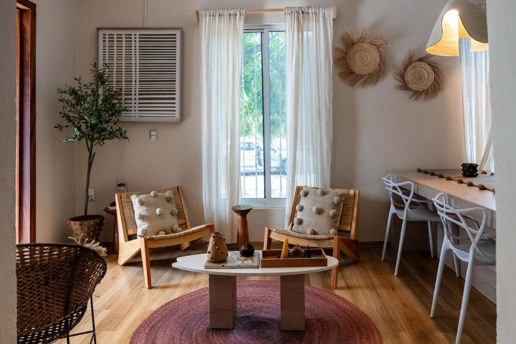 a living room with a table and chairs and a table at Casa MarEscondido in Puerto Escondido