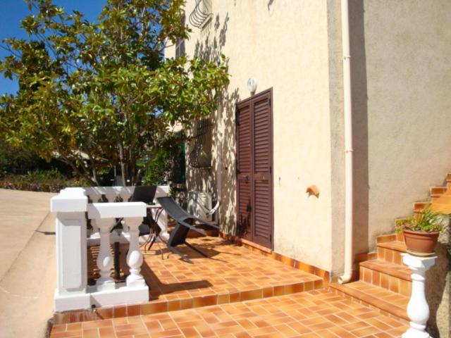 a brick patio with a wooden door and a bench at Sole e Mare in Galeria