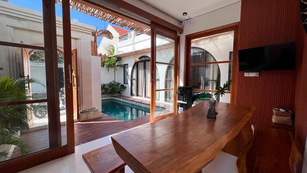 a dining room with a table and a view of a pool at Arrum Villa in Ungasan
