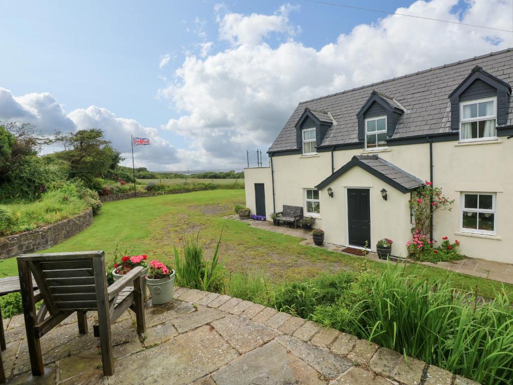 a white house with a bench in front of it at North Studdock Cottage in Pembroke