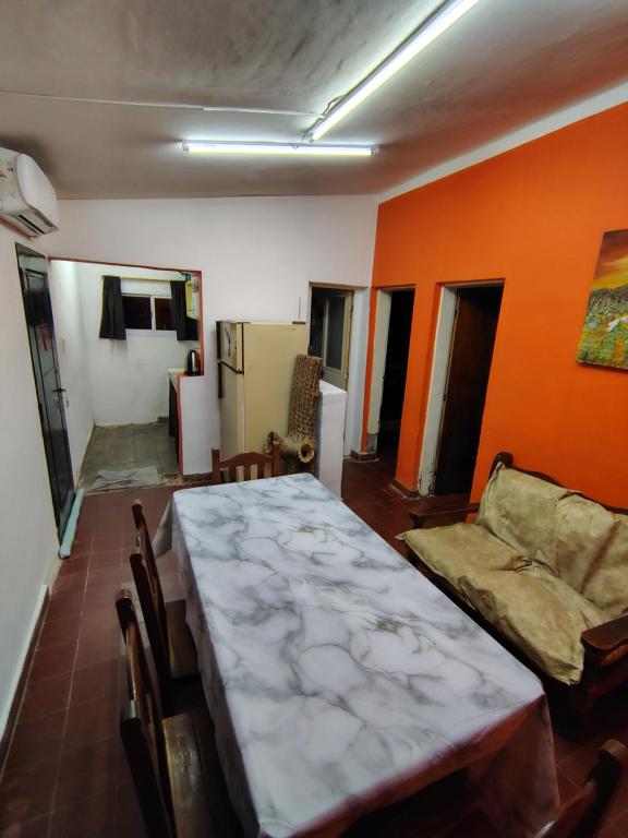 a dining room with a table and a couch at La casita de José in Villa Unión
