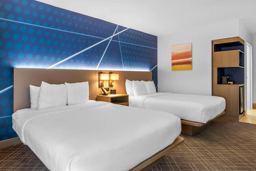 a hotel room with two beds and a blue wall at Comfort Inn Douglasville - Atlanta West in Douglasville