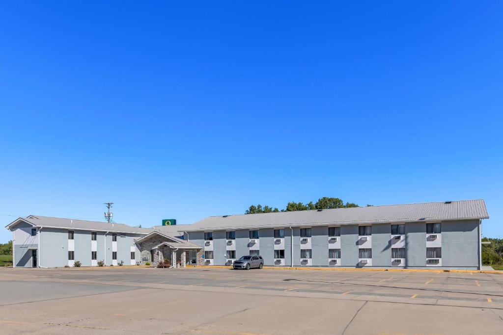 a large white building with a parking lot at Quality Inn Oskaloosa in Oskaloosa