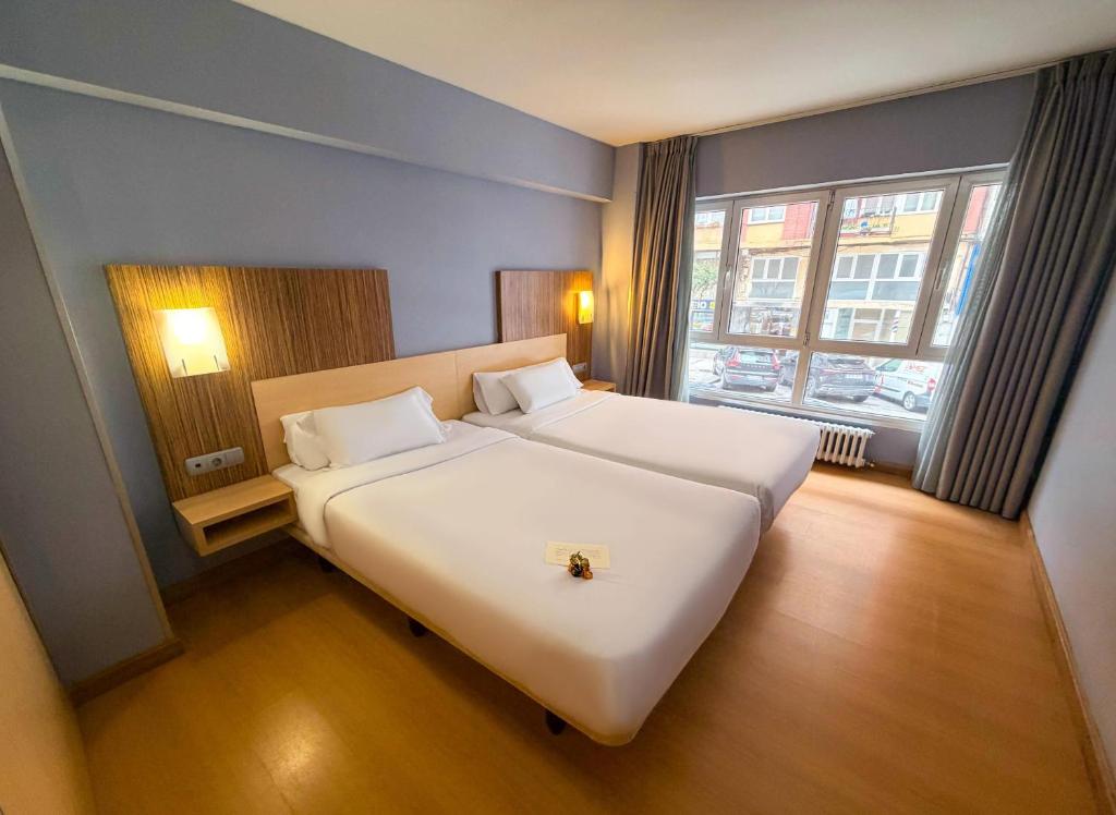 a bedroom with a large white bed and a window at Hotel Faranda Alisas Santander, Ascend Hotel Collection in Santander