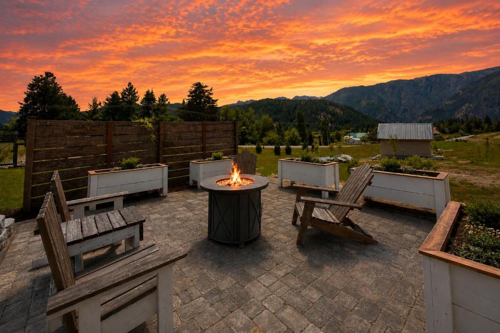 a patio with chairs and a fire pit with a sunset at Berg Haus Home in Leavenworth