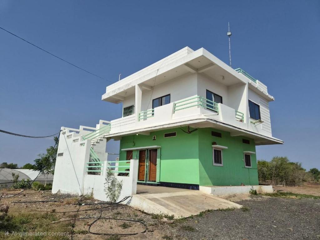 a green and white house with a balcony at Serene Farmhouse in Nimarkheri