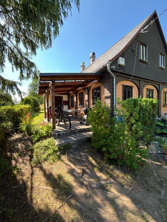 a log home with a porch and a bike on the porch at Roubenka Na vršku in Staré Křečany