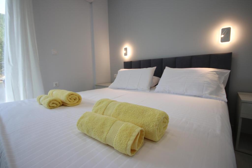 a bedroom with two towels on a white bed at Avli Rooms in Himare