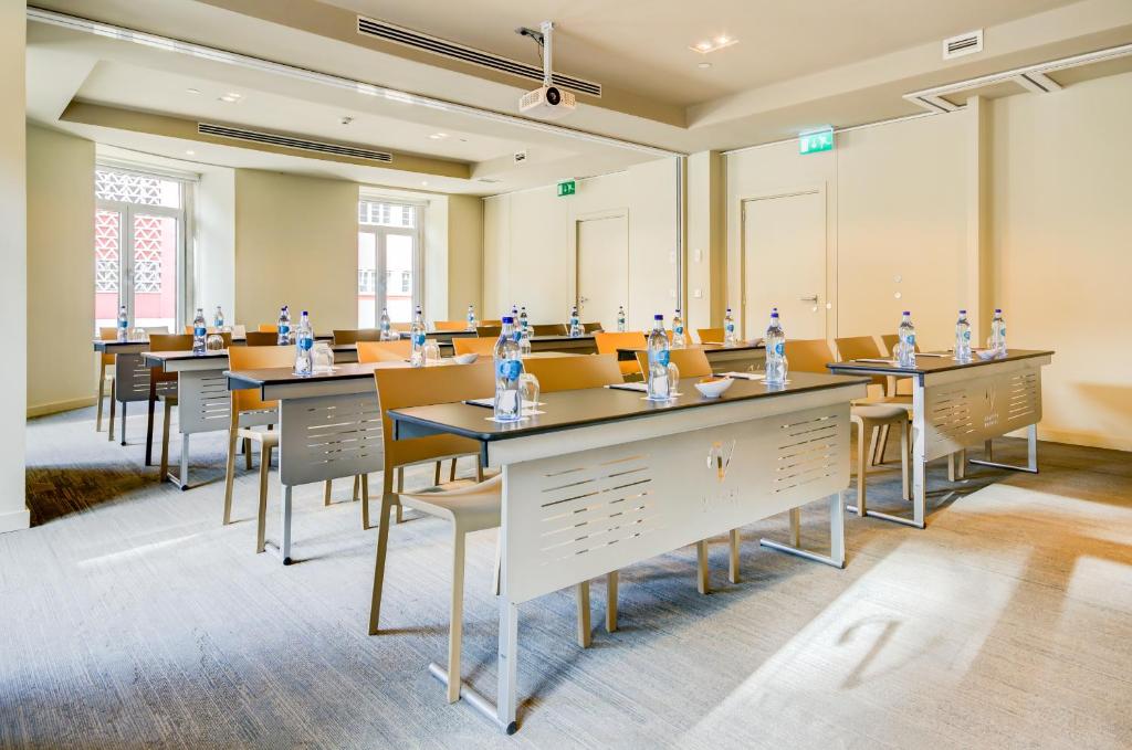 A classroom-style meeting room with a ceiling projector and movable tables.