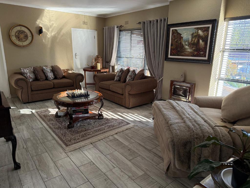 a living room with couches and a coffee table at Sweet Willa Bed and Breakfast in Roodepoort