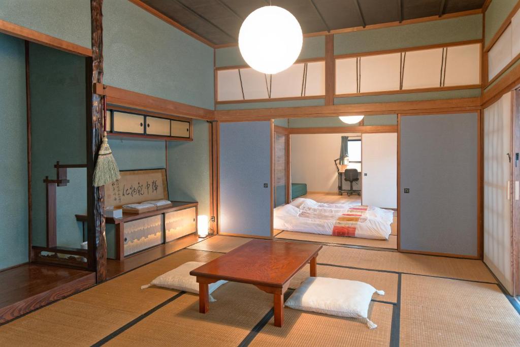 a bedroom with a bed and a table in a room at ISEZI Historic Machiya in Shibata