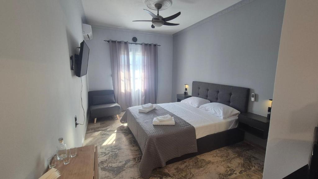 a bedroom with a bed and a ceiling fan at Wide shore Apt in Kamári