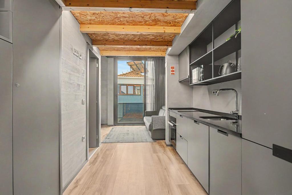 a kitchen with wooden ceilings and a hallway with a view at Apartamento do Laço in Aveiro