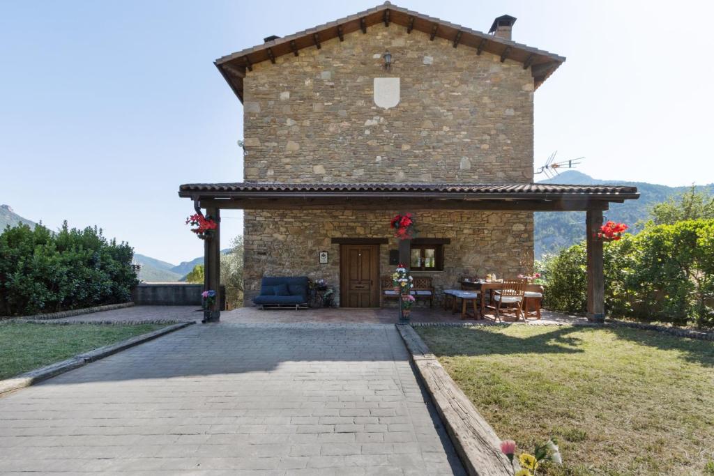 a large stone building with a patio in a yard at Casa Montenegro Las Colladas in Las Colladas
