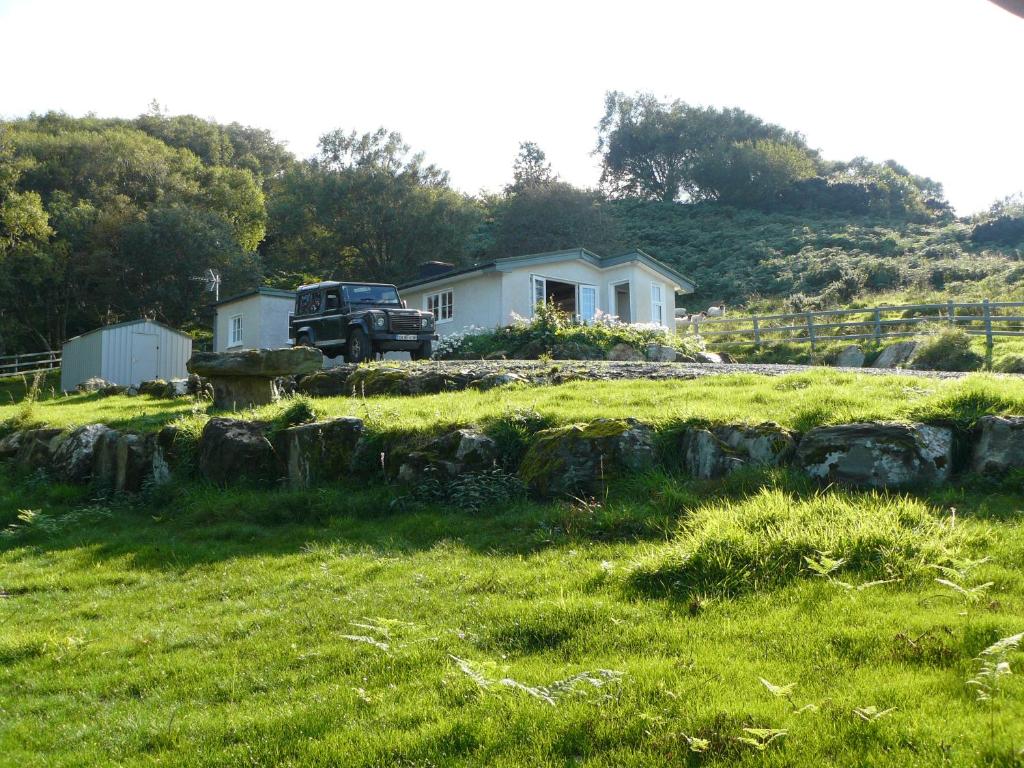 a truck parked in front of a house in a field at Roberts’ Cottage in Westport