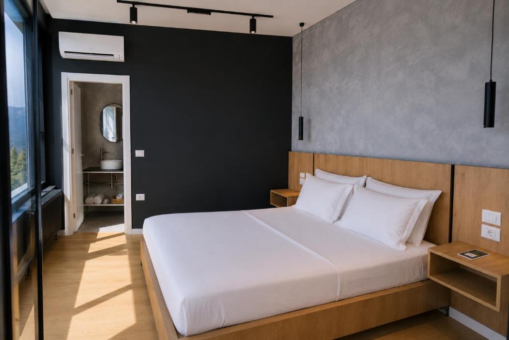 a bedroom with a white bed and a black wall at NOOR Boutique Hotel in Koplik