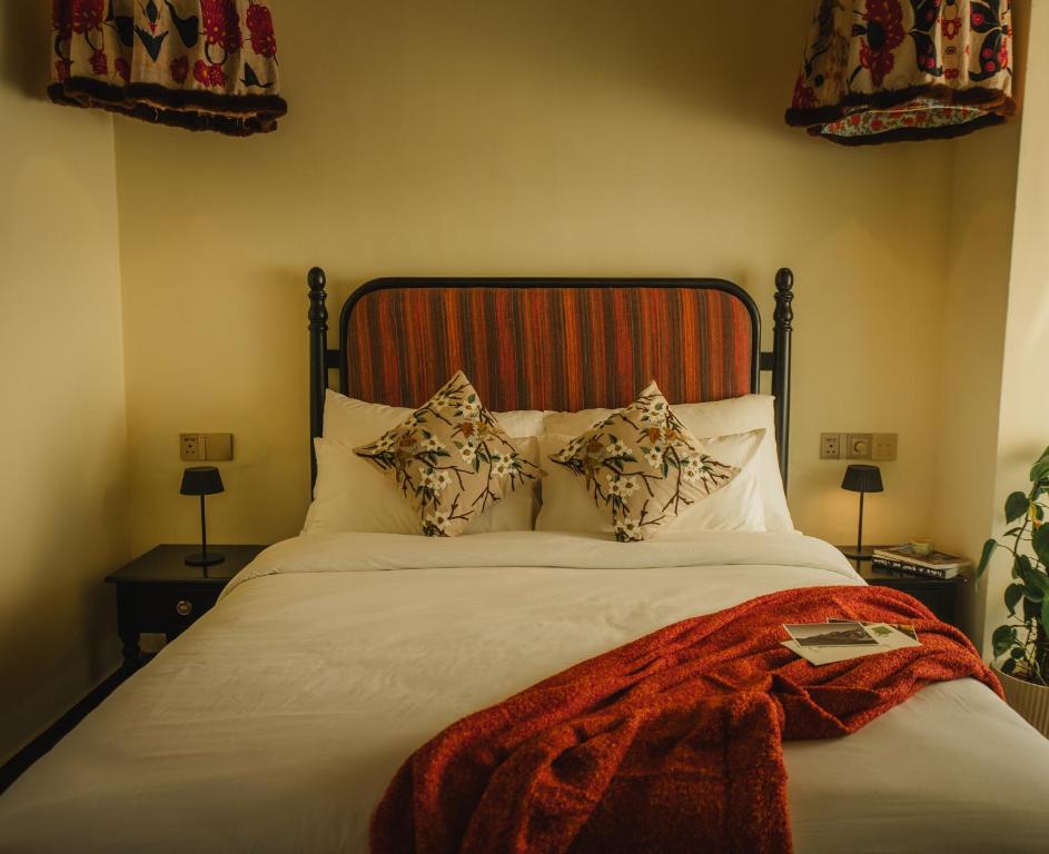 a bedroom with a large white bed with pillows at MONKEY RESORT in McLeod Ganj