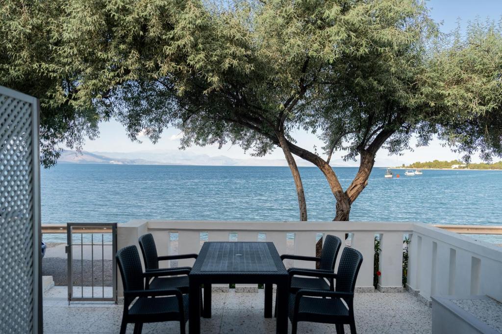 a table and chairs on a balcony overlooking the water at Nerea Eleon Residences in Eleonas