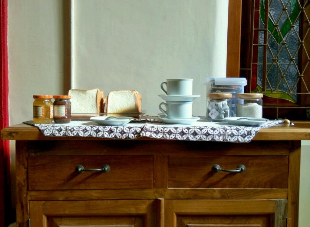 a table with plates and bowls on top of it at Omah Pitoe Yogya Homestay in Yogyakarta