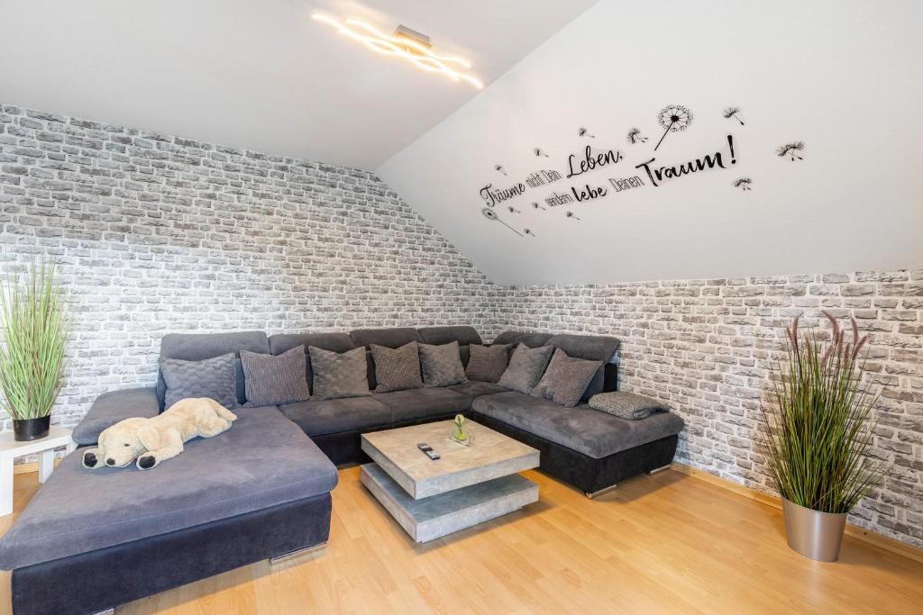 a living room with a couch and a brick wall at Fewowe Ferienwohnung Wenden in Wenden