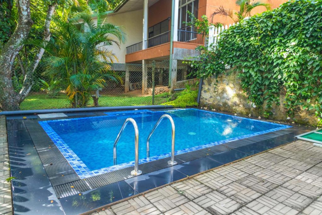 a swimming pool in front of a house at Mango Villa in Kengalla
