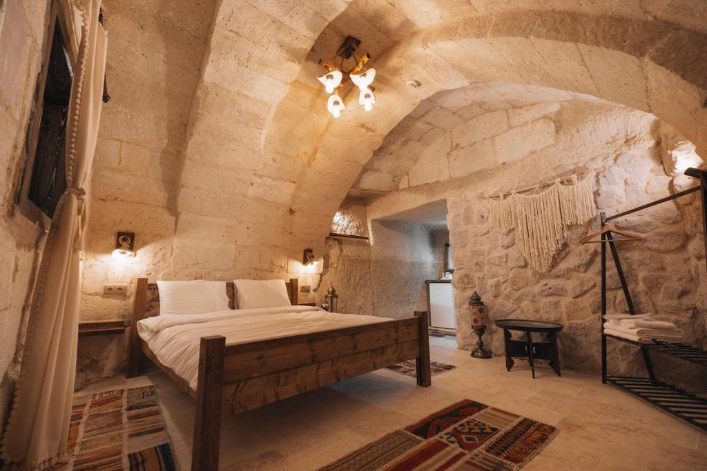 a bedroom with a bed in a stone wall at Velum Cappadocia in Göreme