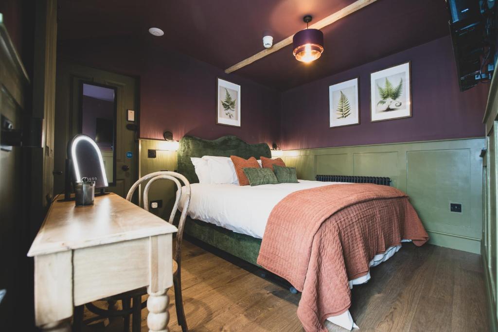 a bedroom with a large bed and a table at The Linen Rooms in Knutsford