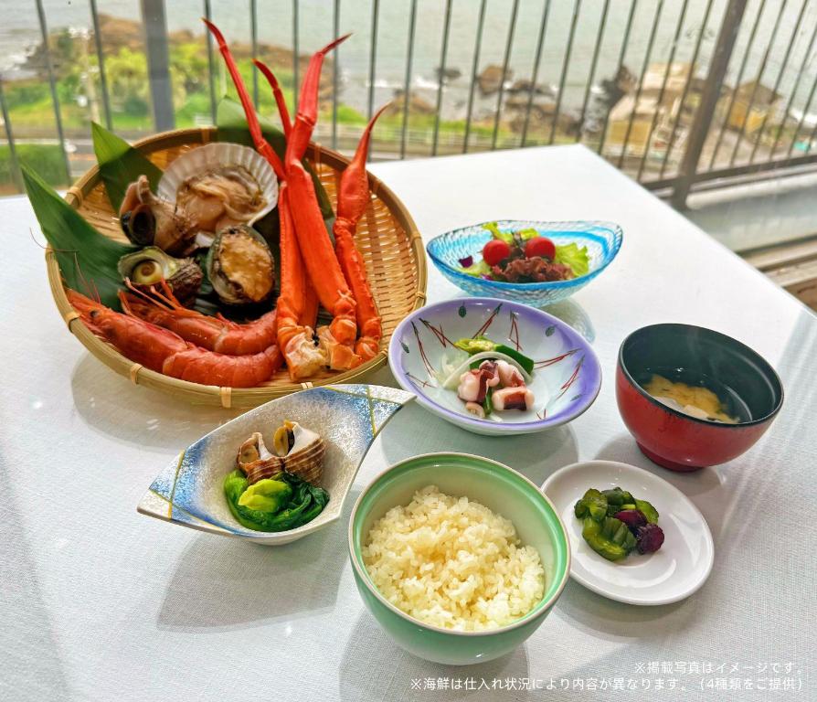 a table with bowls of food and a bowl of rice at 海凪旅館 in Tateyama
