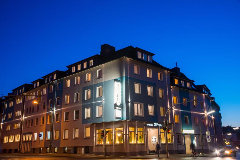 un edificio en la esquina de una calle por la noche en Hotel Westermann en Osnabrück