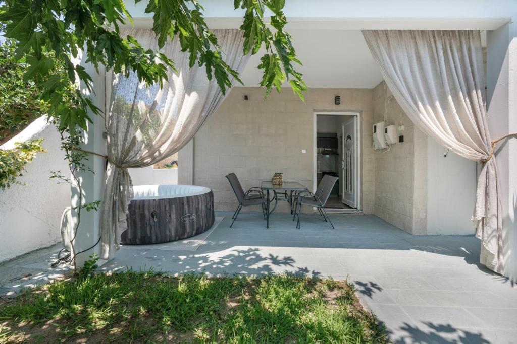 a patio with a table and chairs and trees at 30Roses House in Sálakos