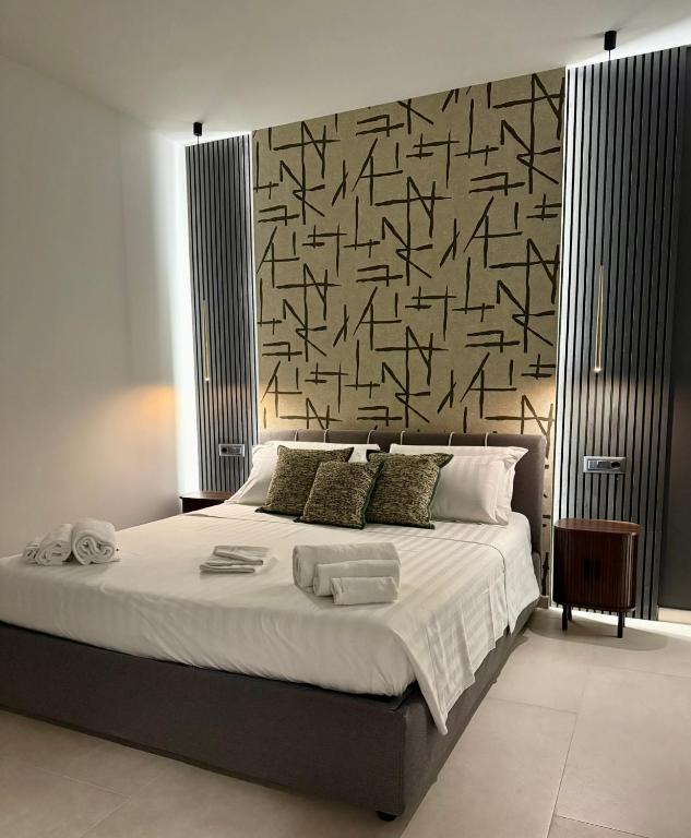a bedroom with a large bed with a black and white wall at H Luxury Apartment Crispi in Olbia