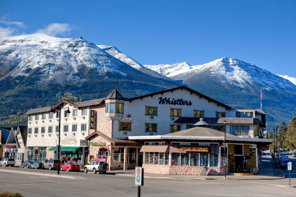 a building on a street with mountains in the background at Whistler's Inn in Jasper