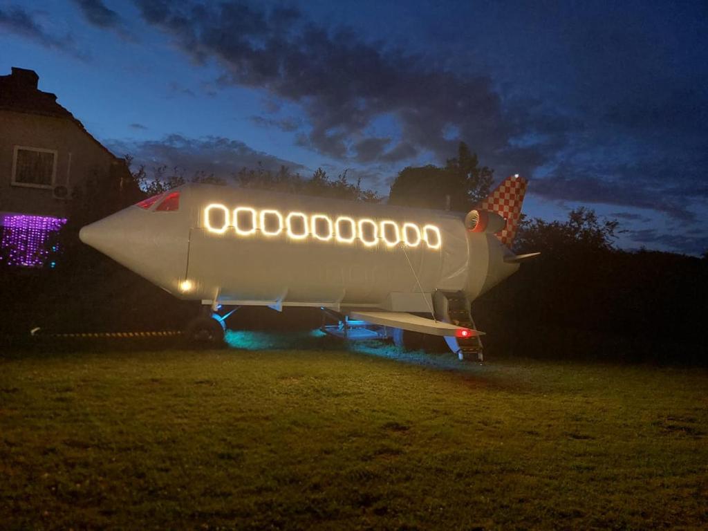 a plane parked in a field at night at Sky Airplane in Tilburg