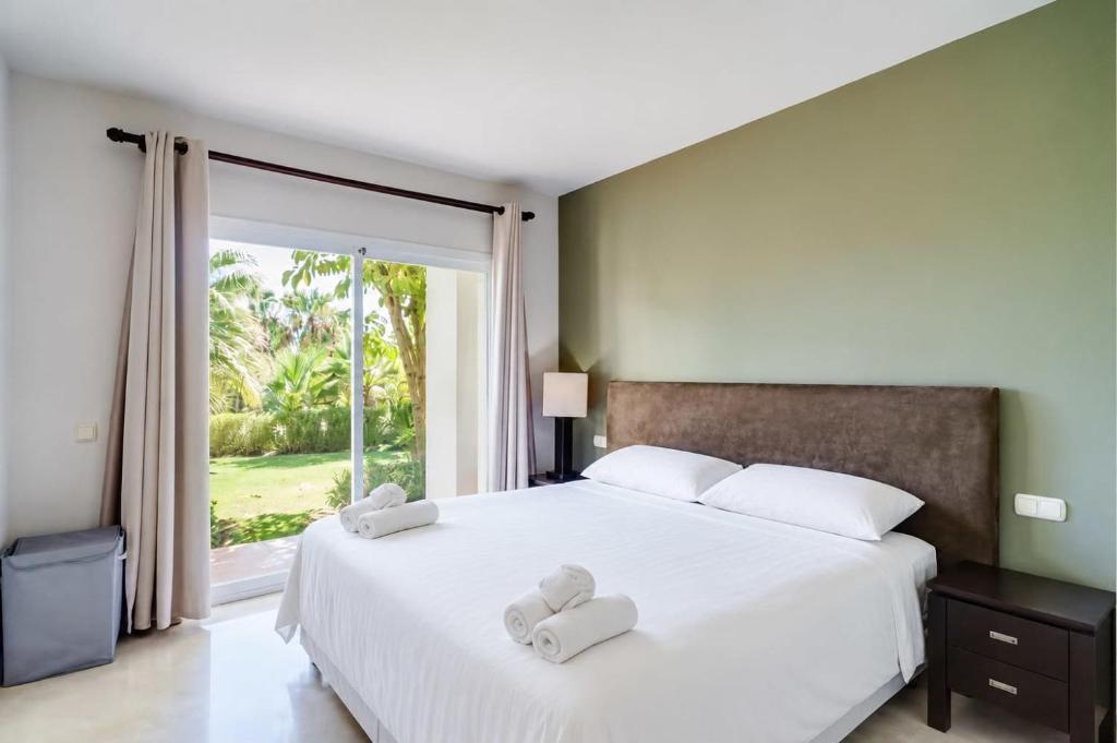 a bedroom with a bed with two towels on it at The Lagoon Apartment- Free Lagoon Access in Estepona