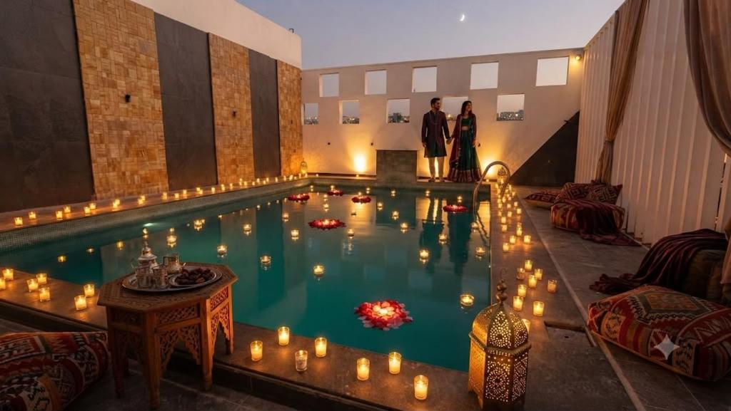 a pool with candles in it with two people standing in it at Waves P'opin Resort in Mahabalipuram