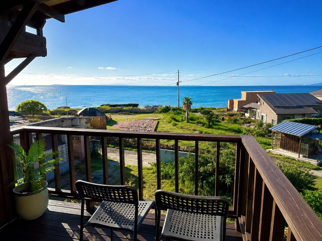 a balcony with chairs and a view of the ocean at Emeraldia in Tateyama