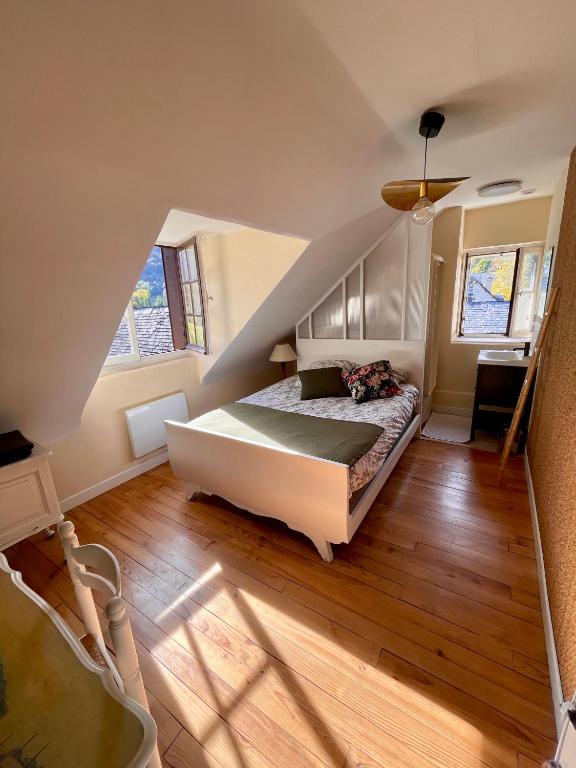 a bedroom with a bed and a staircase with windows at Altitude 875 in Arrens-Marsous