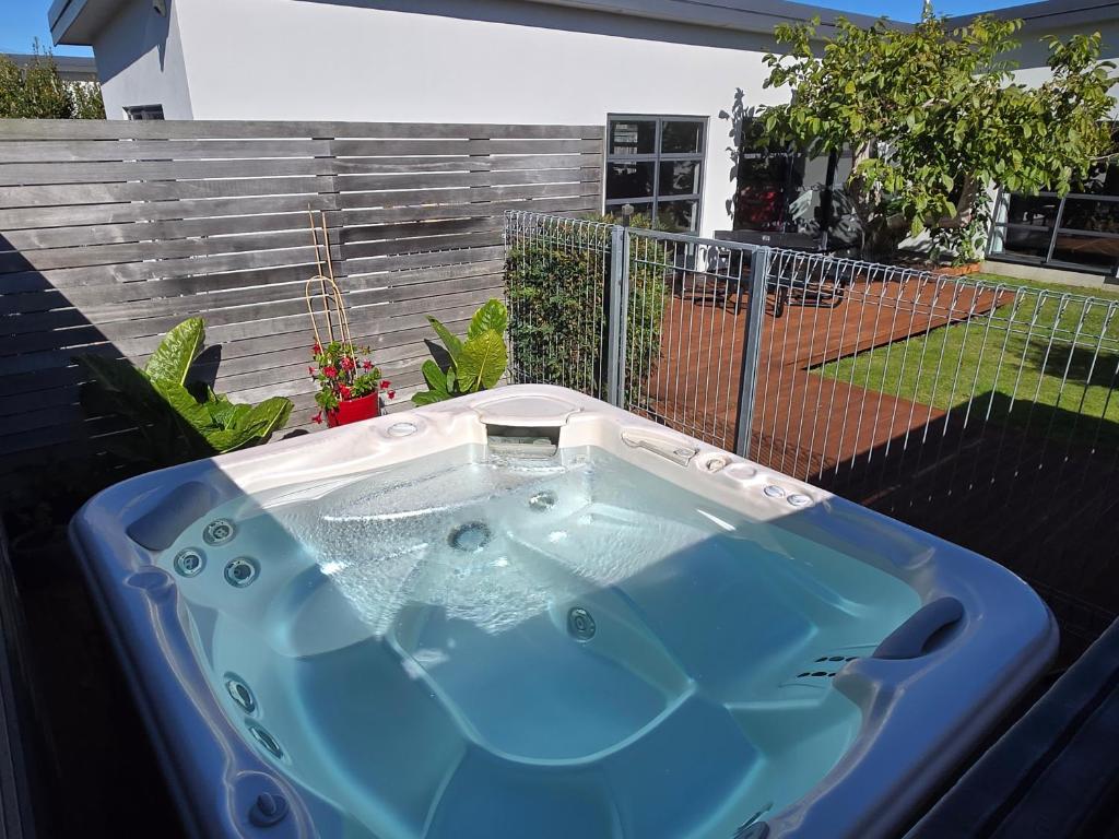 a jacuzzi tub in a backyard with a fence at De Vine Martinborough #14a in Martinborough